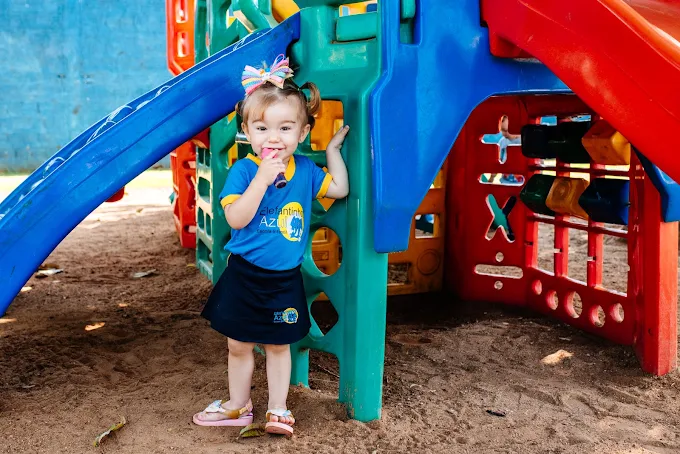 Criança no parque de areia com brinquedo de escalada